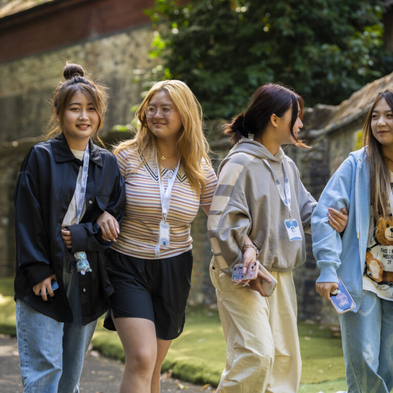 girls walking hand in hand down a path