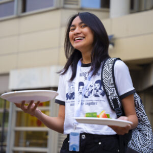 student holding 2 plates of fruit