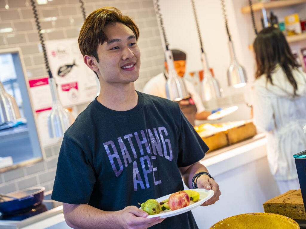 student with plate of fruit