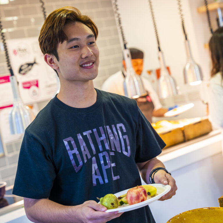 student with plate of fruit