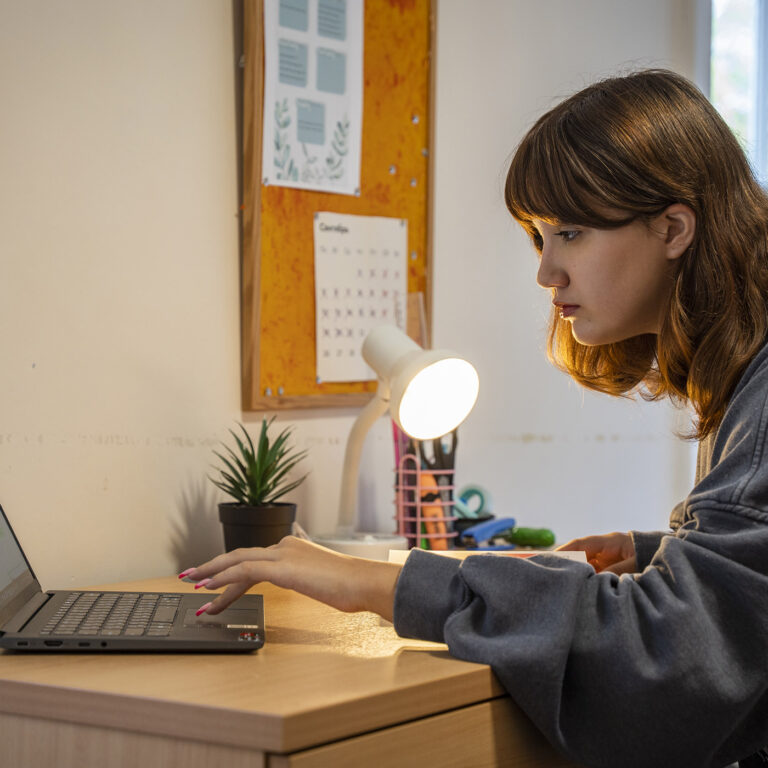 girl in her dorm room studying