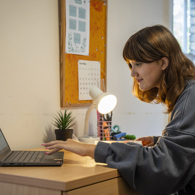 girl in her dorm room studying