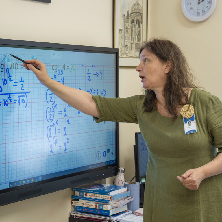 teacher writing on a smart board