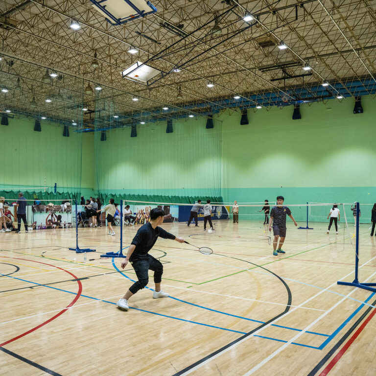 students playing badminton in a sports hall